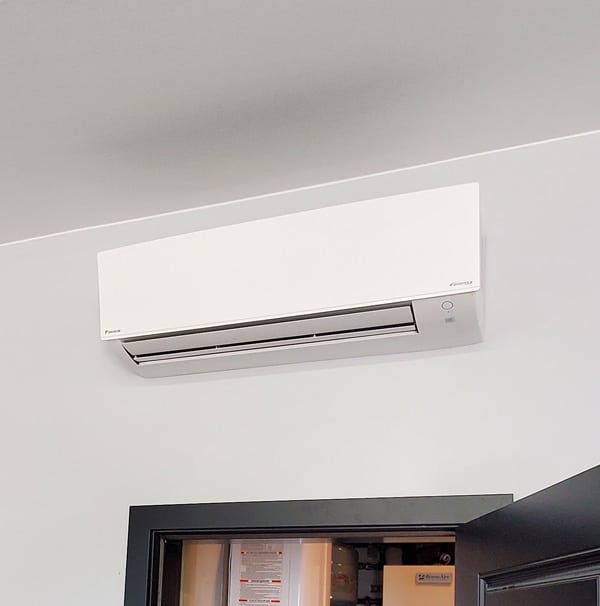 A ductless mini split mounted above a door