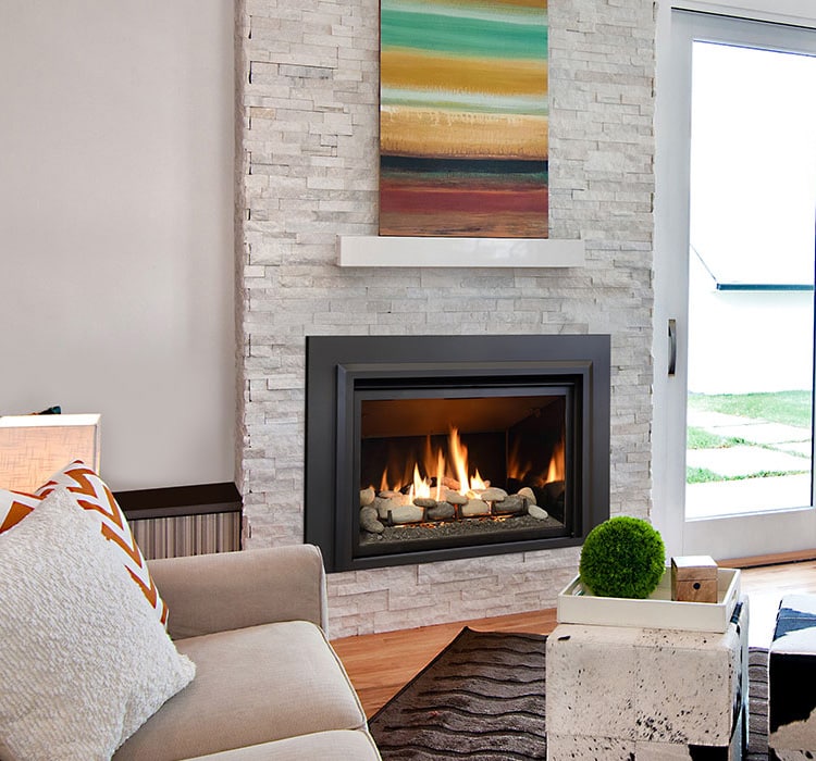A gas fireplace roars in the center of a living room with light walls and furniture.