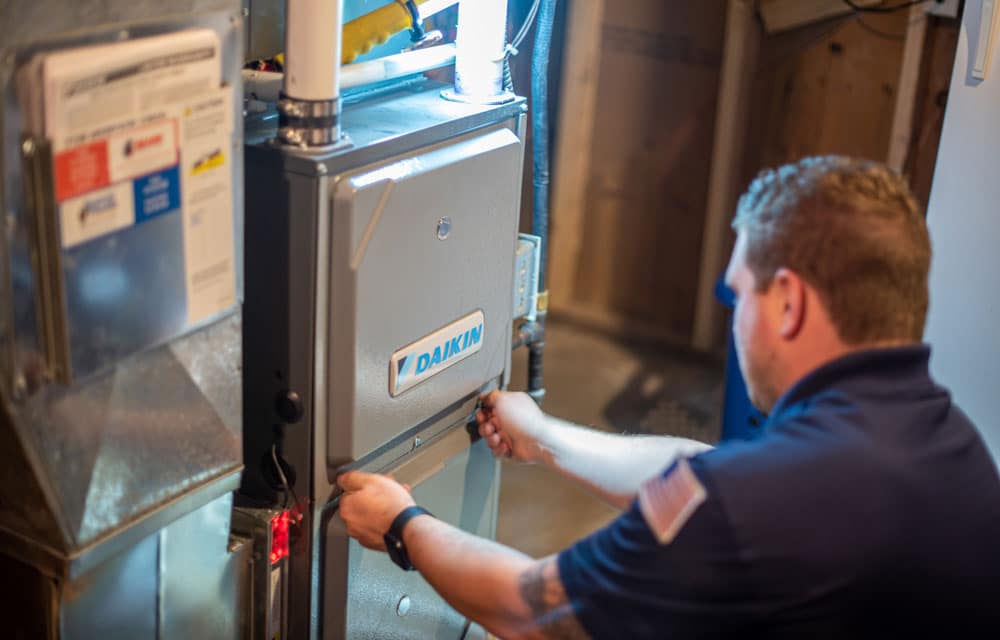 A heating and cooling specialist checks efficiency of air conditioning unit.