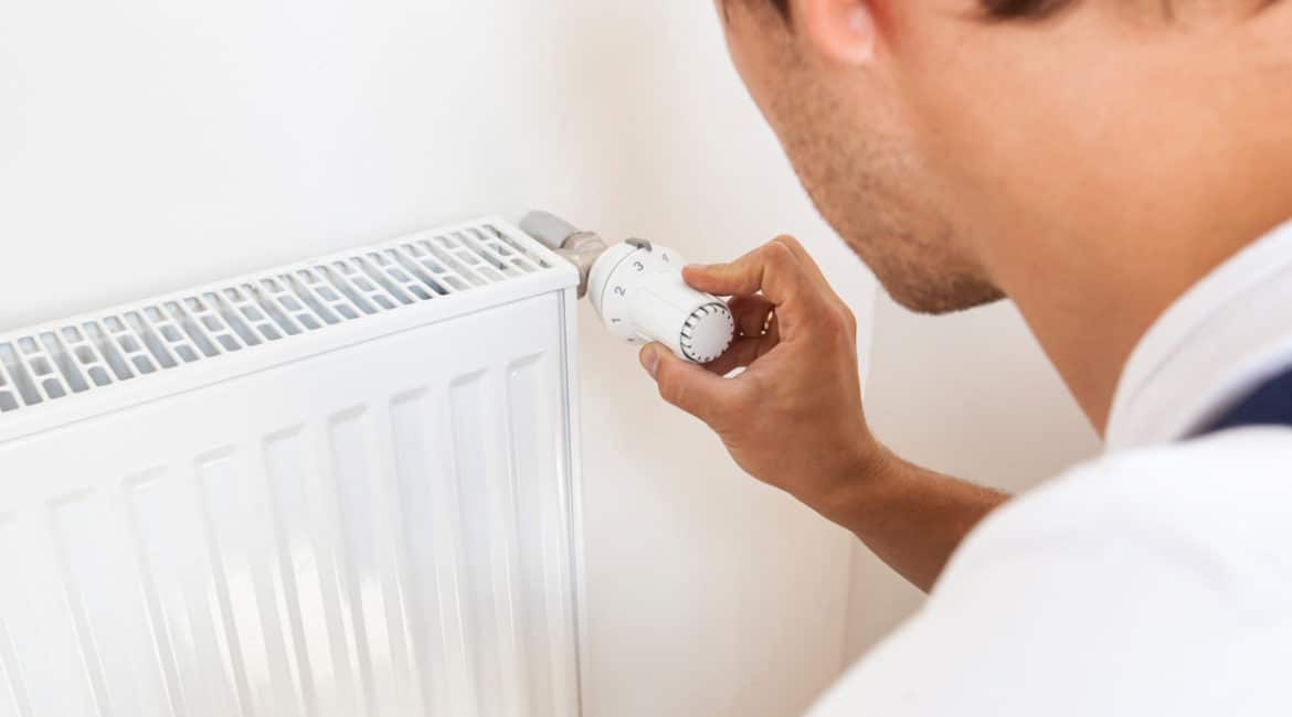 man-adjusting-temperature-of-radiator