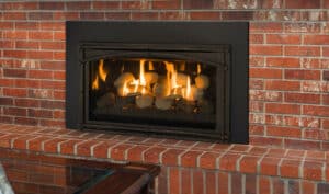 A Chaska Kozy Heat fireplace insert with a brick surround