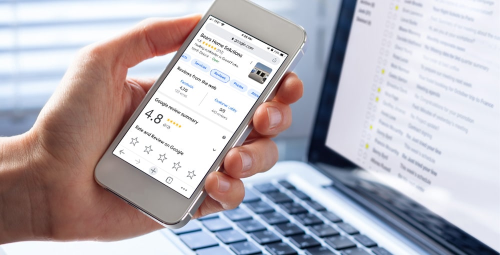 A close-up of a person holding a smartphone with the Google page of Bears Home Solutions on the screen 