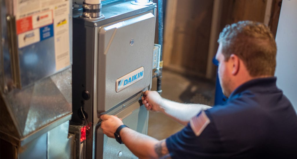 Bears Home Solutions certified specialist examines HVAC unit.