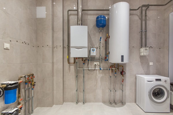 A mounted gas boiler and electric water heater in a home boiler room