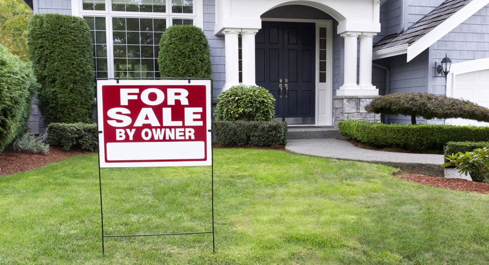 “For Sale By Owner” sign outside of house.